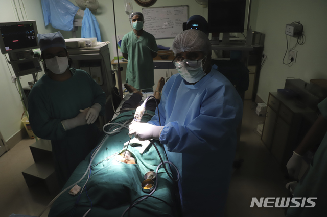 [뉴델리=AP/뉴시스]23일(현지시간) 인도 뉴델리 외곽지역인 가지아바드에서 한 의사가 털곰팡이증 제거 수술을 집도하고 있다. 2021.05.24.