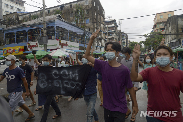 [양곤(미얀마)=AP/뉴시스]미얀마 최대 도시 양곤에서 5월24일 아웅산 수지 전 국가고문에 대한 재판에 항의하는 시위대가 세 손가락 포즈를 취한 채 가두 행진을 벌이고 있다. 2021.06.19.