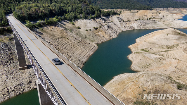 %5[오로빌( 미 캘리포니아주)= AP/뉴시스] 심한 이른 가뭄으로 댐수위가 낮아져 도로가 하늘에 떠있는듯한 오로빌 댐 일대의 풍경. 이 사진을 찍은 6월 3일 이 댐은 연평균 46%의 담수량보다도 더 낮은 39%의 수위를 보이고 있었지만 지금은 훨씬 더 말라붙어 작아졌다.  