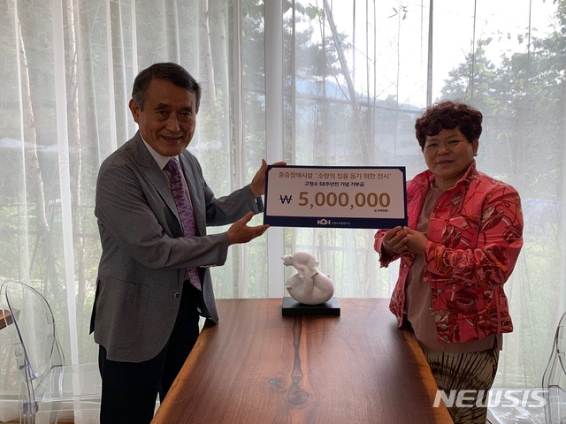 [서울=뉴시스] 고정수 조각가가 전시 수익금 500만원을 소망의집 중증장애 시설에 기부했다.