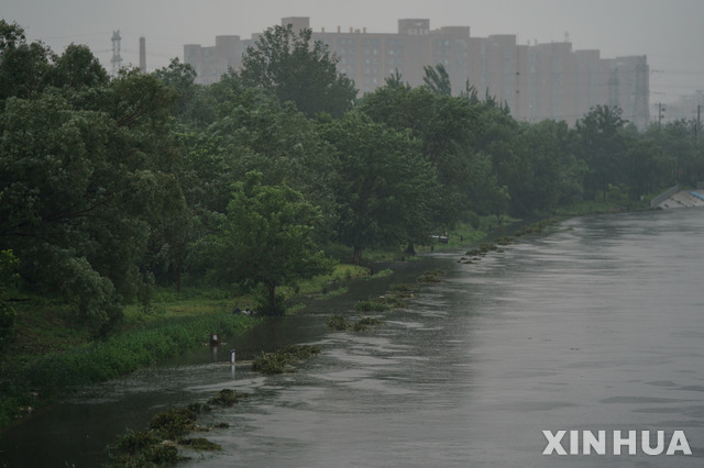 [베이징=신화/뉴시스] 12일 베이징의 량수이허 주변 산책로가 불어난 강물에 잠긴 모습. 11일부터 이날까지 수도 베이징을 포함해 수도권에서도 폭우가 이어졌다. 2021.07.13