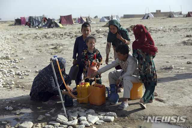 [마자르이샤리프(아프가니스탄)=AP/뉴시스]지난 8일 아프가니스탄 북부 마자르 이 샤리프 외곽 한 캠프에서 물통을 채우는 아프간인들. 이들은 탈레반의 아프간 북부 지역 점령을 피해 집을 떠났다. 2021.07.14.photo@newsis.com