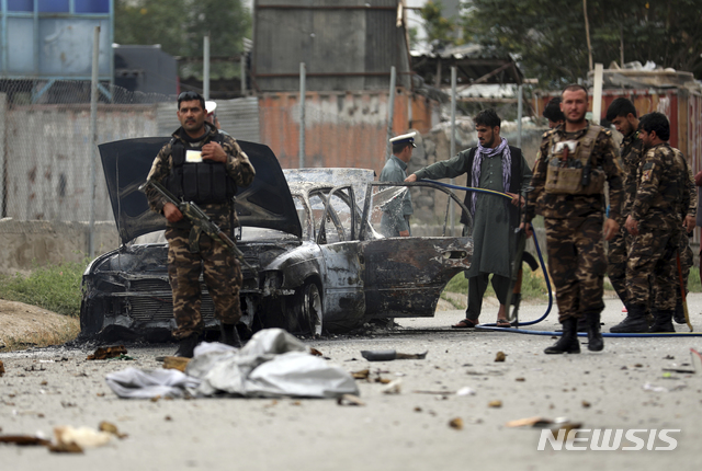 [카불=AP/뉴시스]지난 20일(현지시간) 아프간 보안요원들이 수도 카불 대통령궁 인근에 떨어진 최소 3발의 로켓포 공격으로 파손된 차량을 살펴보고 있다. 2021.07.25.