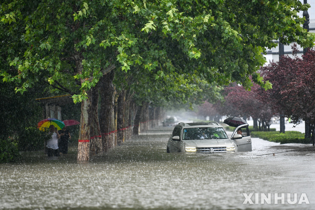 [정저우=신화/뉴시스]지난 20일(현지시간) 기록적인 폭우가 내린 중국 허난성 성도 정저우에서 자동차 한 대가 물에 잠겨 있다. 2021.07.24.