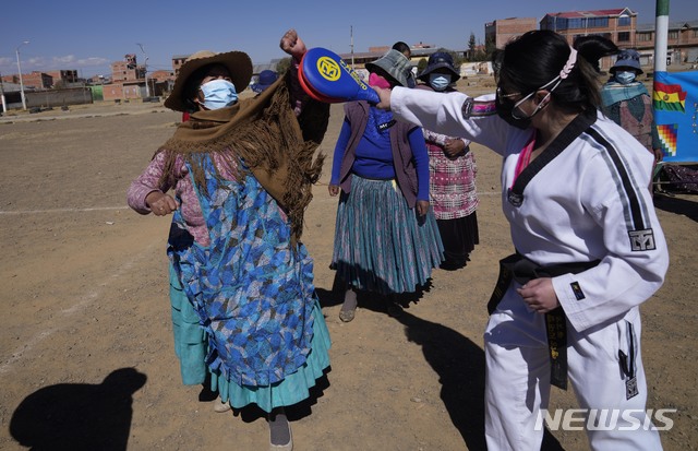 [엘알토=AP/뉴시스] 22일(현지시간) 볼리비아 엘 알토에서 태권도 사범 로라 로카(오른쪽)가 아이마라 부족 여성들에게 태권도를 가르치고 있다. 아이마라(Aymara)와 여성(Woman)을 뜻하는 말을 합친 '워미 파워'(Warmi Power)라고도 불리는 태권도 사범들은 아이마라 부족 여성들의 가정 폭력 피해 예방을 위해 5년 전부터 이들에게 태권도를 가르쳐왔다. 2021.07.23.