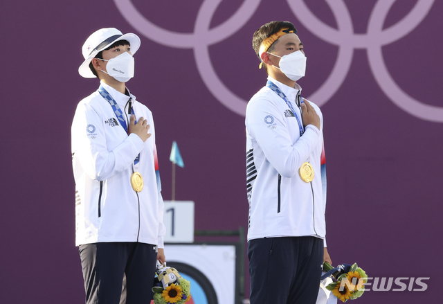 [도쿄(일본)=뉴시스] 최진석 기자 = 대한민국 양궁 대표팀 안산과 김제덕이 24일 오후 일본 도쿄 유메노시마 양궁장에서 열린 2020 도쿄올림픽 양궁 남녀혼성단체전 결승에 우승을 차지한 뒤 금메달을 목에 걸고 국민의례하고 있다. 2021.07.24. myjs@newsis.com