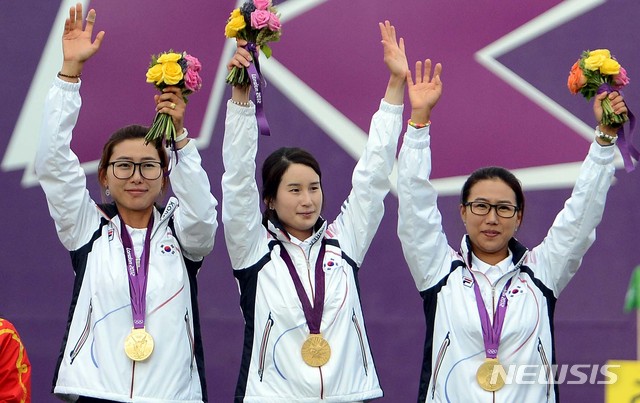 [런던(영국)=뉴시스] 2012년 영국 런던 로드 크리켓 가든에서 열린 런던올림픽 여자 양궁 단체전 대한민국과 중국의 결승전에서 극적으로 중국을 꺽은 대한민국 최현주(왼쪽부터), 기보배, 이성진이 금메달을 목에 걸고 손을 들어 인사를 하고 있다. 2위는 중국, 3위는 일본. (사진=뉴시스 DB) 2021.07.26. photo@newsis.com