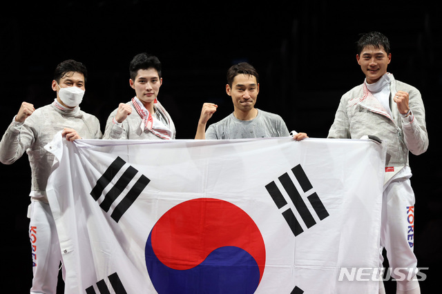 [지바(일본)=뉴시스] 최진석 기자 = 대한민국 펜싱 대표팀이 28일 오후 일본 지바 마쿠하리 메세 B홀에서 열린 도쿄올림픽 펜싱 남자 사브르 단체 결승전 이탈리아와의 경기에서 승리해 금메달을 결정지은 뒤 태극기를 들며 기뻐하고 있다. 2021.07.28. myjs@newsis.com