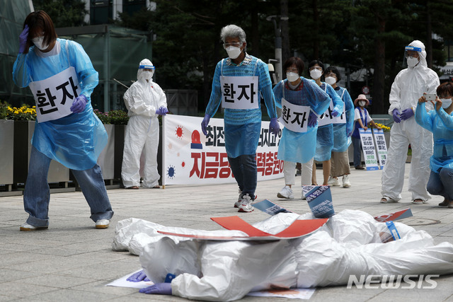 [서울=뉴시스] 홍효식 기자 = 민주노총 공공운수노조 의료연대 조합원들이 지난 8월5일 오전 서울시청 앞에서 코로나19 감염병상 간호인력 기준마련을 요구하며 방호복을 입고 퍼포먼스를 하고 있다. 2021.08.05. yesphoto@newsis.com