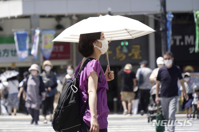  [도쿄=AP/뉴시스] 5일 일본 도쿄에서 코로나19 확산을 막기 위해 마스크를 쓴 시민들이 거리를 걷고 있다. 일본 정부는 이날 오전 코로나19 전문가 회의인 '기본적대처방침 분과회'를 열고 코로나19 긴급사태 선언에 준하는 '만연방지 등 중점조치(중점조치)' 적용 지역을 8곳 추가할 것으로 알려졌다. 2021.08.05. 