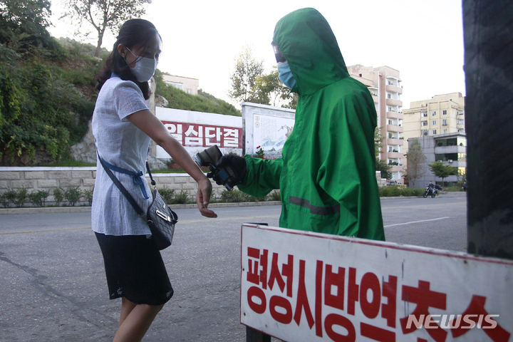 [평성=AP/뉴시스] 1일 북한 평안남도 평성의 한 방역소에서 보건 관계자가 시민들을 상대로 코로나19 예방을 위한 방역 활동을 하고 있다. 2021.09.02.