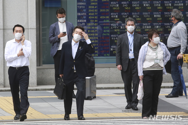 [도쿄(일본)=AP/뉴시스]지난 6일 일본의 한 증권사 전광판 앞에서 마스크를 착용한 시민들이 길을 건너기 위해 기다리고 있다. 2021.09.08.