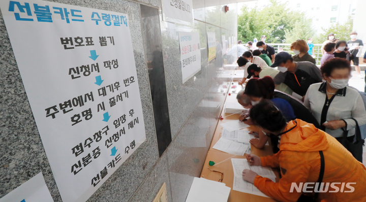 [전주=뉴시스] 김얼 기자 = 코로나 상생 국민지원금 현장 신청 첫날인 13일 전북 전주시 완산구 서신동 주민센터에서 지원금을 신청하기 위해 몰려든 시민들로 북새통을 이루고 있다. 2021.09.13. pmkeul@newsis.com