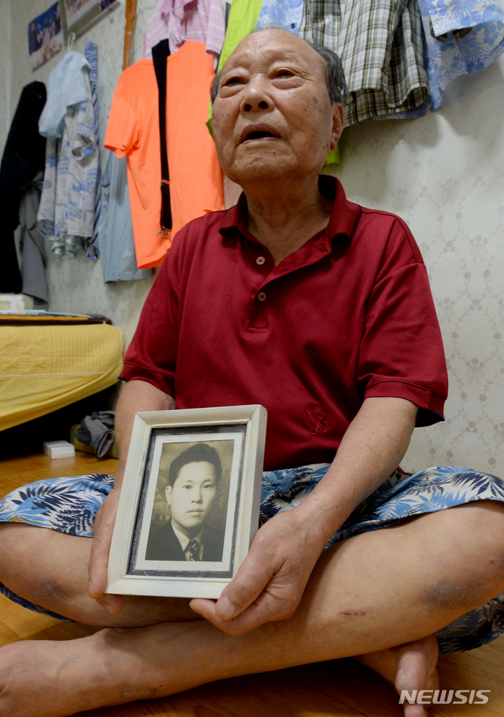 [광주=뉴시스] 김혜인 기자 = 광주 지역 이산가족 김천수(87)씨가 지난 16일 광주 남구 자택에서 청년시절 자신의 사진을 든 채 취재진의 질문에 답하고 있다. 2021.09.19.hyein0342@newsis.com