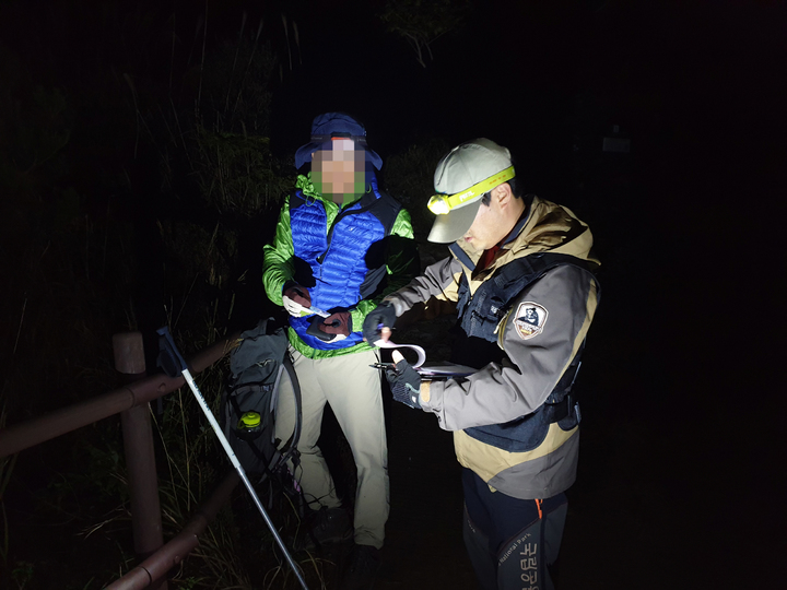 [광주=뉴시스] 김혜인 기자 = 국립공원공단 무등산국립공원사무소 관계자가 야생동물 서식환경을 훼손하는 야간 산행을 단속하고 있다. (사진=무등산국립공원사무소 제공) 2021.09.26.photo@newsis.com *재판매 및 DB 금지