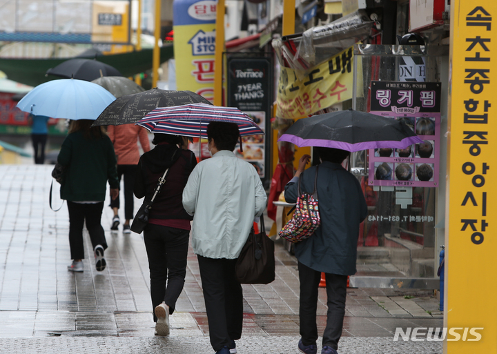 [속초=뉴시스] 김경목 기자 = 가을비가 내리는 29일 오전 시민·관광객들이 우산을 쓰고 강원도 속초시 속초관광수산시장으로 걸어가고 있다. 2021.09.29. photo31@newsis.com