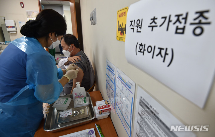 [대구=뉴시스] 이무열 기자 = 지난 14일 오후 대구 서구 대구의료원 라파엘웰빙센터 코로나19 예방접종센터에서 의료진이 추가접종(부스터샷)을 접종 받고 있다. 코로나19 확진자 치료병원 종사자 중 예방접종 완료 후 6개월이 지난 사람은 오는 30일까지 화이자 백신 3회차 접종에 들어간다. 2021.10.14. lmy@newsis.com