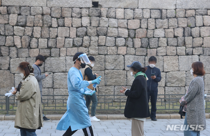 [서울=뉴시스] 고승민 기자 = 동대문종합시장에서 코로나19 집단감염이 발생한 이튿날인 20일 서울 흥인지문 옆에 설치된 서울시 찾아가는 선별진료소를 찾은 상인 등 시민들이 검사를 받기 위해 줄을 서고 있다. 2021.10.20. kkssmm99@newsis.com