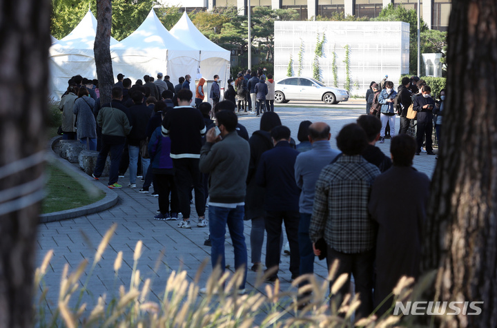 [서울=뉴시스] 고승민 기자 = 동대문종합시장에서 코로나19 집단감염이 발생한 이튿날인 20일 서울 흥인지문 옆에 설치된 서울시 찾아가는 선별진료소를 찾은 상인 등 시민들이 검사를 받기 위해 줄을 서고 있다. 2021.10.20. kkssmm99@newsis.com