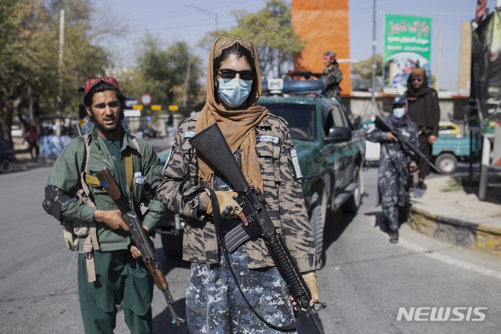 [카불=AP/뉴시스] 21일(현지시간) 아프가니스탄 수도 카불 여성 시위 현장에서 탈레반 대원들이 경계를 펼치고 있다. 탈레반은 이날 시위를 통제하던 중 기자와 여성들을 또 폭행했다. 2021.10.22.