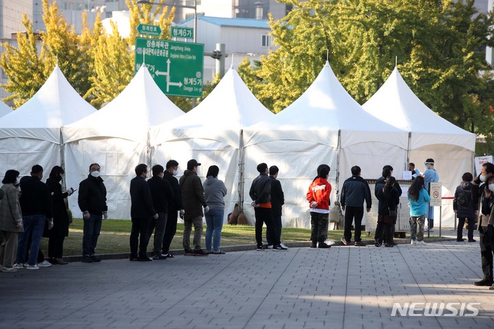 [서울=뉴시스] 김선웅 기자 = 0시 기준 1440명의 신규 코로나19 확진자가 발생한 지난 22일 오전 서울 종로구 흥인지문(동대문) 인근에 설치된 선별진료소에서 시민들이 검사를 받기 위해 줄을 서고 있다. 2021.10.22. mangusta@newsis.com