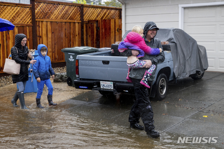 [샌타로사=AP/뉴시스] 24일(현지시간) 미 캘리포니아주 샌타로사에서 한 가족이 폭우로 인한 침구 지역에서 대피하고 있다. 캘리포니아 북부를 뒤덮은 폭우로 산사태와 홍수가 발생해 도로가 침수되고 주민이 고립되는 등 피해가 발생했다. 2021.10.25.