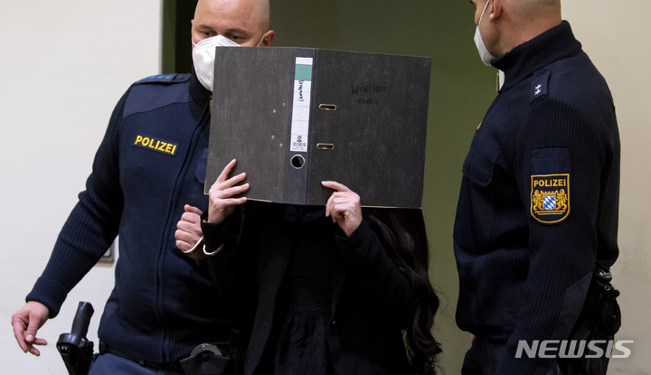 [뮌헨=AP/뉴시스] 이른바 이슬람국가(IS) 신부였던 독일 여성 제니퍼 W.가 25일(현지시간) 독일 뮌헨 법정에 들어서며 폴더로 얼굴을 가리고 있다. 2021.10.26.