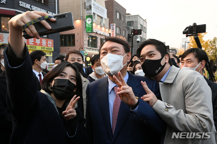 [서울=뉴시스] 국회사진기자단 = 윤석열 국민의힘 대선 경선 후보가 3일 서울 마포구 경의선숲길을 방문해 청년 지지자들과 기념촬영을 하고 있다. 2021.11.03. photo@newsis.com