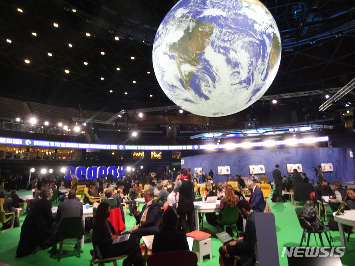 [글래스고=뉴시스]이지예 특파원= 제26차 유엔 기후변화협약 당사국총회(COP26)가 열린 영국 글래스고 스코티쉬이벤트캠퍼스(SEC) 안의 대형 지구 모형 아래에서 참가자들이 회의하고 있다. 2021.11.3.