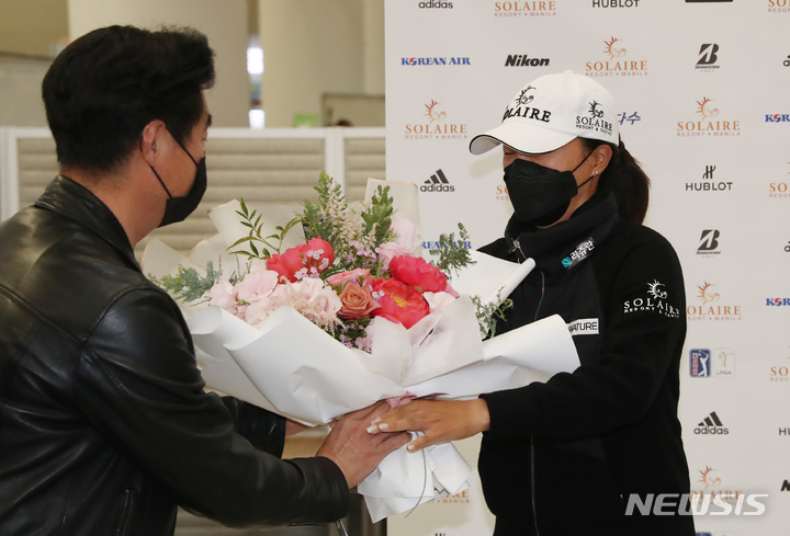 [인천공항=뉴시스] 고승민 기자 = 미국 여자프로골프(LPGA) 투어 2021 시즌 최종전에서 우승하며 다승왕, 상금왕과 올해의 선수상까지 석권하는 '3관왕'을 달성하고 금의환향한 고진영이 23일 오후 인천국제공항 제2터미널을 통해 귀국, 꽃다발을 받고 있다. 2021.11.23. kkssmm99@newsis.com