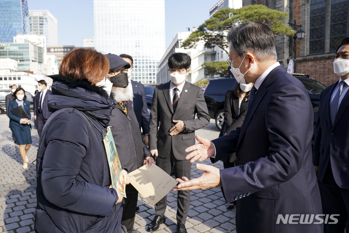 [서울=뉴시스] 전진환 기자 = 문재인 대통령이 25일 국가인권위원회 설립 20주년 기념식이 열린 서울 중구 명동성당 꼬스트홀 앞에서 고 이예람 중사 부모로부터 면담요청 등 요구사항이 담긴 입장문을 받고 있다. 2021.11.25. amin2@newsis.com