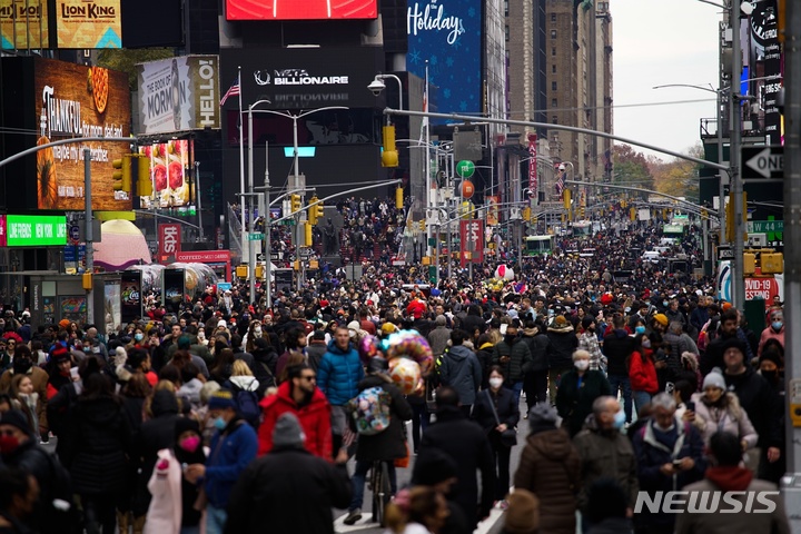 [뉴욕=AP/뉴시스] 25일(현지시간) 미국 뉴욕에서 메이시스 추수감사절 퍼레이드가 끝난 후 시민들이 타임스퀘어를 걷고 있다. 2021.11.26.
