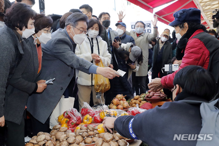 [장흥=뉴시스] 최동준 기자 = 이재명 더불어민주당 대선 후보가 27일 전남 장흥군 정남진장흥토요시장을 방문해 음식 구매를 하고 있다. 2021.11.27. photocdj@newsis.com