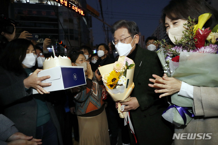 [순천=뉴시스] 최동준 기자 = 이재명 더불어민주당 대선 후보, 부인 김혜경 씨가 27일 전남 순천 연향상가 패션거리를 방문해 지지자에게 생일 케이크를 받고 있다. 2021.11.27. photocdj@newsis.com