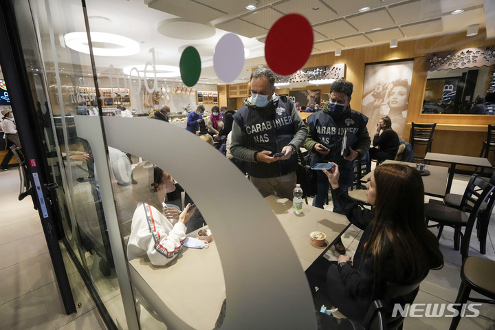 [로마=AP/뉴시스]이탈리아 로마의 한 식당에서 경찰이 이용객들의 슈퍼그린패스 소지 여부를 검사하고 있다. 2021.12.6.