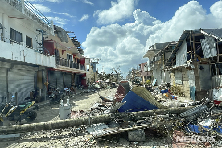 [세부=AP/뉴시스] 19일(현지시간) 필리핀 세부의 한 거리에 태풍 '라이'로 전신주가 쓰러지고 가옥들이 파괴돼 있다. 제22호 태풍 '라이'로 최소 146명이 숨지고 30만 명의 이재민이 발생한 것으로 나타났다. 2021.12.20.