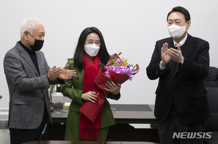 [서울=뉴시스] 국회사진기자단 = 윤석열 국민의힘 대선 후보가 20일 서울 여의도 새시대준비위원회 사무실에서 새시대준비위 수석부위원장으로 합류한 신지예 한국여성정치네트워크 대표 환영식을 하고 있다. 2021.12.20. photo@newsis.com