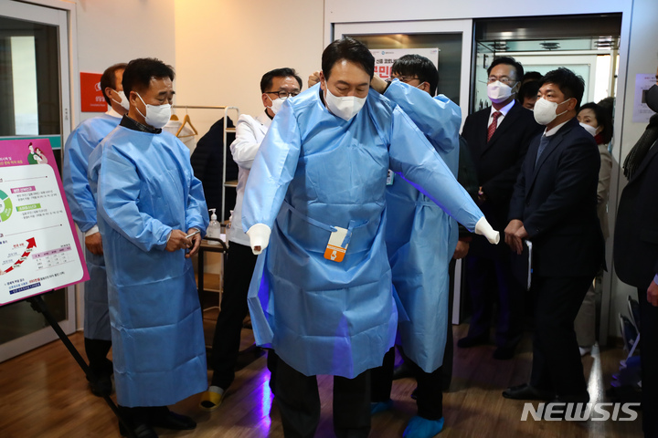 [서울=뉴시스] 국회사진기자단 = 윤석열 국민의힘 대선 후보가 20일 강원도 철원 공공 산후조리원을 방문해 위생복을 입고 있다. 2021.12.20. photo@newsis.com