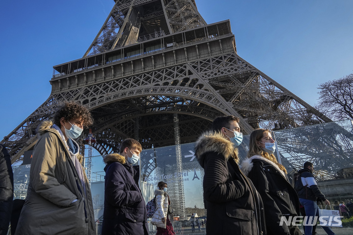 [파리=AP/뉴시스] 21일(현지시간) 프랑스 파리에서 마스크를 쓴 시민들이 에펠탑 주변을 지나고 있다. 프랑스는 오미크론 변이의 확산을 막기 위한 별도의 봉쇄를 하지 않는 대신 백신 접종을 촉진하기 위한 입법을 추진한다. 가브리엘 아탈 정부 대변인은 식당과 공공장소 출입 시 백신 패스 소지를 의무화하는 법률이 다음 달 중순 통과되길 바란다고 밝혔다. 2021.12.22.