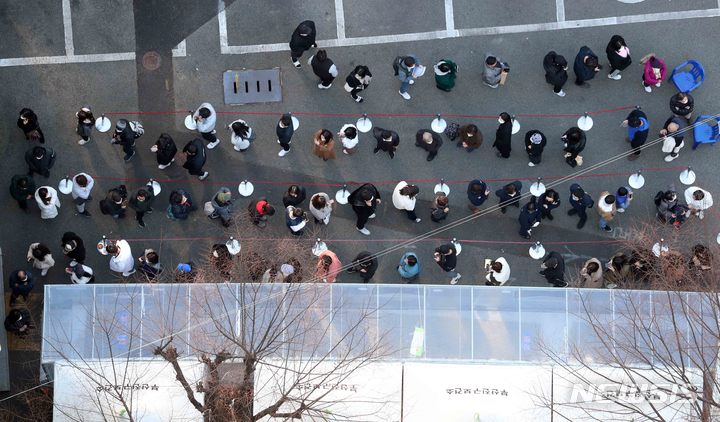 [부산=뉴시스] 지난 22일 오후 부산진구 보건소 선별진료소를 찾은 시민들이 진단검사를 받기 위해 길게 줄을 선 채 자신의 차례를 기다리고 있다. photo@newsis.com