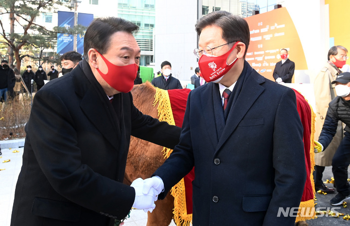 [서울=뉴시스] 국회사진기자단 = 이재명 더불어민주당 대선 후보, 윤석열 국민의힘 대선 후보가 지난 3일 서울 여의도 한국거래소에서 열린 2022 증시대동제에 참석해 악수하고 있다. 2022.01.03. photo@newsis.com