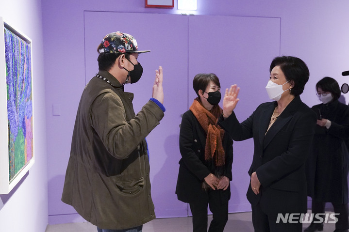 [서울=뉴시스] 김정숙 여사가 7일 오후 서울 서초구 예술의전당 서예박물관에서 열린 '붓으로 틀을 깨다, 한국 발달장애 아티스트 특별초대전'에서 작가와 인사하고 있다. 국내 발달장애 예술인 43명의 작품 100여 점을 선보이는 이 전시는 'Getting Close(다가가다, 가까워지다)'라는 주제로 꿈을 향해 다가가는 장애인 예술가들의 열정을 전하고, 장애인과 비장애인 사이의 거리를 그림으로 가깝게하려는 취지를 담아 마련됐다. (사진=청와대 제공) 2022.01.07. photo@newsis.com