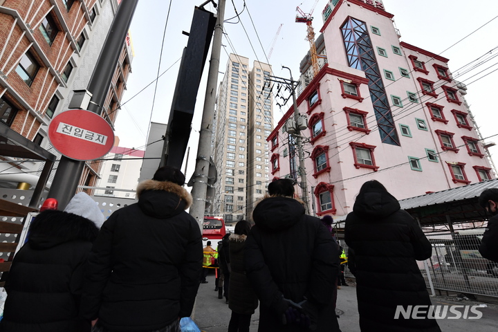 [광주=뉴시스] 변재훈 기자 = 12일 오전 광주 서구 화정동 현대아이파크 외벽 붕괴 현장에서 소재 불명 작업자 가족들이 구조 소식을 기다리며 사고 아파트를 바라보고 있다. 앞서 전날 오후 3시 46분께 화정 현대아이파크 신축 현장에서 201동(완공 시 39층 규모) 23~34층 외벽이 무너져 내려 작업자 6명의 소재가 파악되지 않고있다.2022.01.12. wisdom21@newsis.com