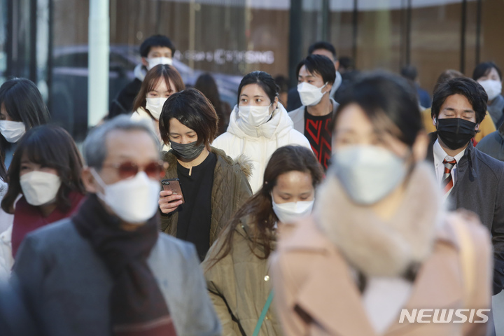 [도쿄(일본)=AP/뉴시스]지난 12일 일본 도쿄의 거리를 코로나19 감염 예방을 위해 마스크를 착용한 시민들이 걸어가고 있다. 2022.01.13