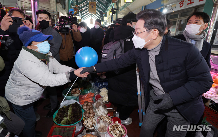 [강릉=뉴시스] 최동준 기자 = 이재명 더불어민주당 대선 후보가 16일 강원 강릉 중앙성남전통시장을 방문해 상인들과 인사하고 있다. (공동취재사진) 2022.01.15. photo@newsis.com