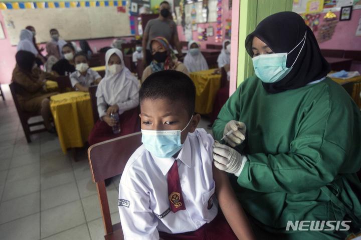 [메단=AP/뉴시스] 17일(현지시간) 인도네시아 북수마트라주 메단의 한 초등학교에서 6~11세 어린이를 대상으로 코로나19 백신 접종을 시행해 한 학생이 시노백 백신을 접종하고 있다. 2022.01.18.
