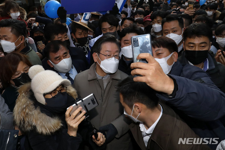 [안성=뉴시스] 국회사진기자단 = 이재명 더불어민주당 대선 후보가 23일 경기 안성시 명동거리에서 열린 '매타버스' 안성, 민심 속으로! 행사에서 시민들과 사진을 찍고 있다. 2022.01.23. photo@newsis.com