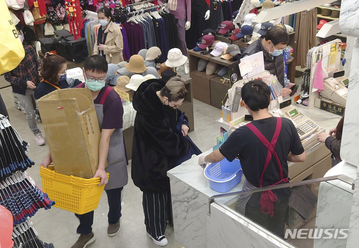 [타이베이=AP/뉴시스] 대만 수도 타이베이 시내에 위치한 쇼핑센터를 12일 찾은 고객들이 코로나19 예방을 위해 마스크를 착용한 채 물건을 사고 있다.2022.02.13