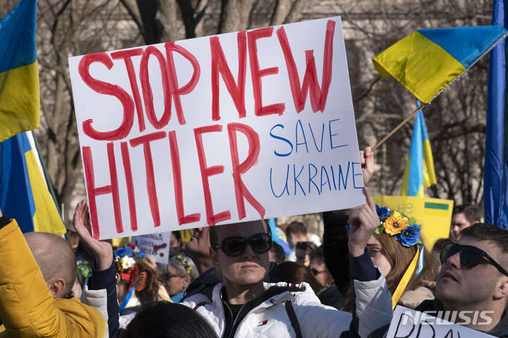 [워싱턴=AP/뉴시스] 27일(현지시간) 워싱턴 백악관 밖에서 러시아의 우크라이나 침공에 반대하는 시위가 열려 시위대가 우크라이나 국기와 손팻말을 들고 있다. 2022.02.28.