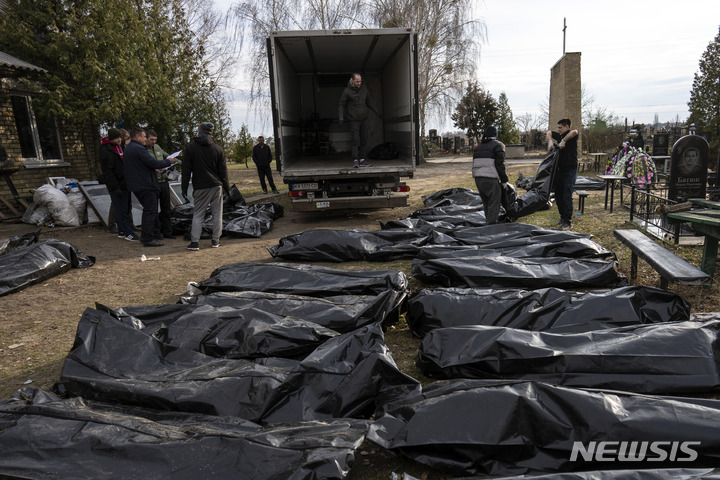 [부차=AP/뉴시스] 6일(현지시간) 우크라이나 키이우 외곽 부차의 공동묘지에서 작업자들이 살해된 민간인들의 시신을 안치소로 보내기 위해 트럭에 싣고 있다. 2022.04.07.